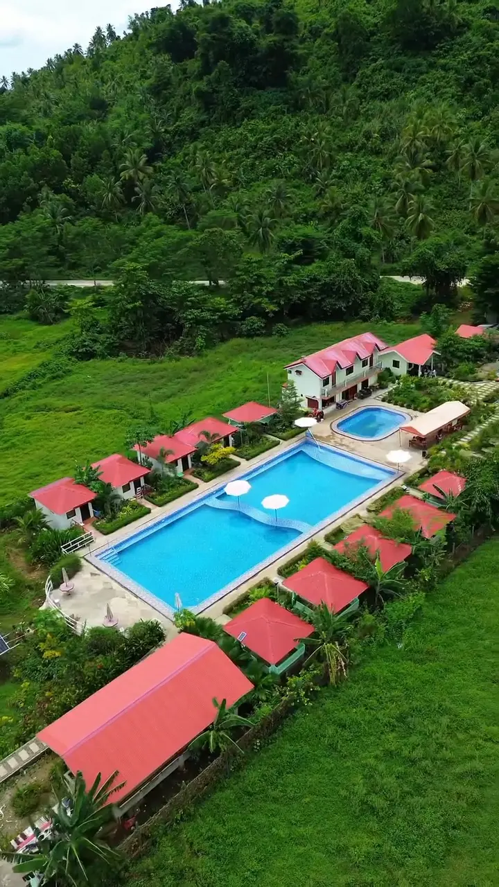 Aerial drone view of Mariden Resort Siargao showing pool, grounds, and surrounding Del Carmen landscape